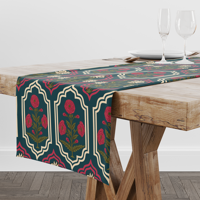 Deep teal table runner with ornate red and cream medallion frames and floral motifs, styled with wine glasses and place settings