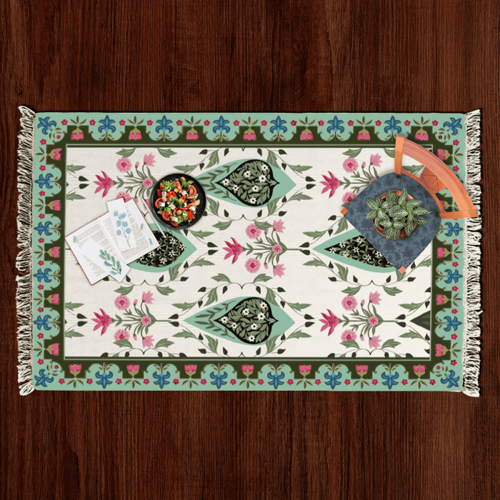 Top-down flat lay of the paisley medallion Dhurrie rug styled with a salad bowl, notecards, and a potted plant