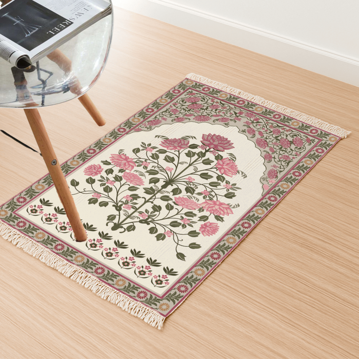 Angled view of the rose bouquet floral medallion Dhurrie rug on a light wood floor beside a chair