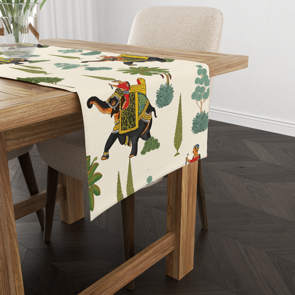 Cream table runner with decorated royal elephants, riders, and tree motifs, shown from another angle on a wooden table with tableware