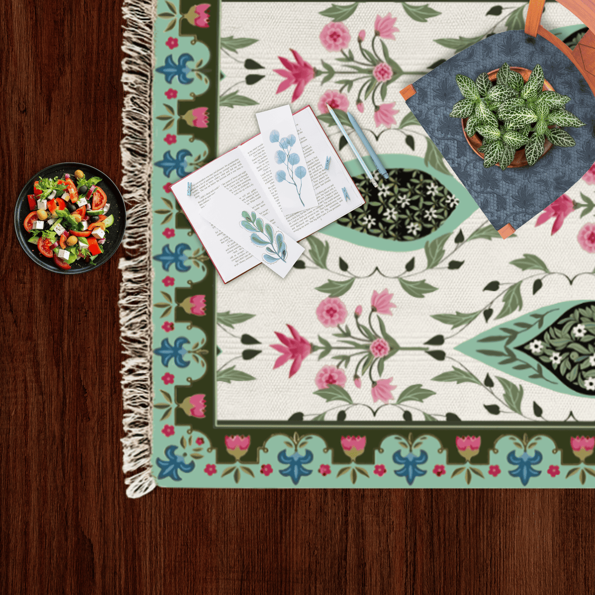 Close-up corner of the paisley medallion Dhurrie rug styled with a small salad bowl and a potted plant