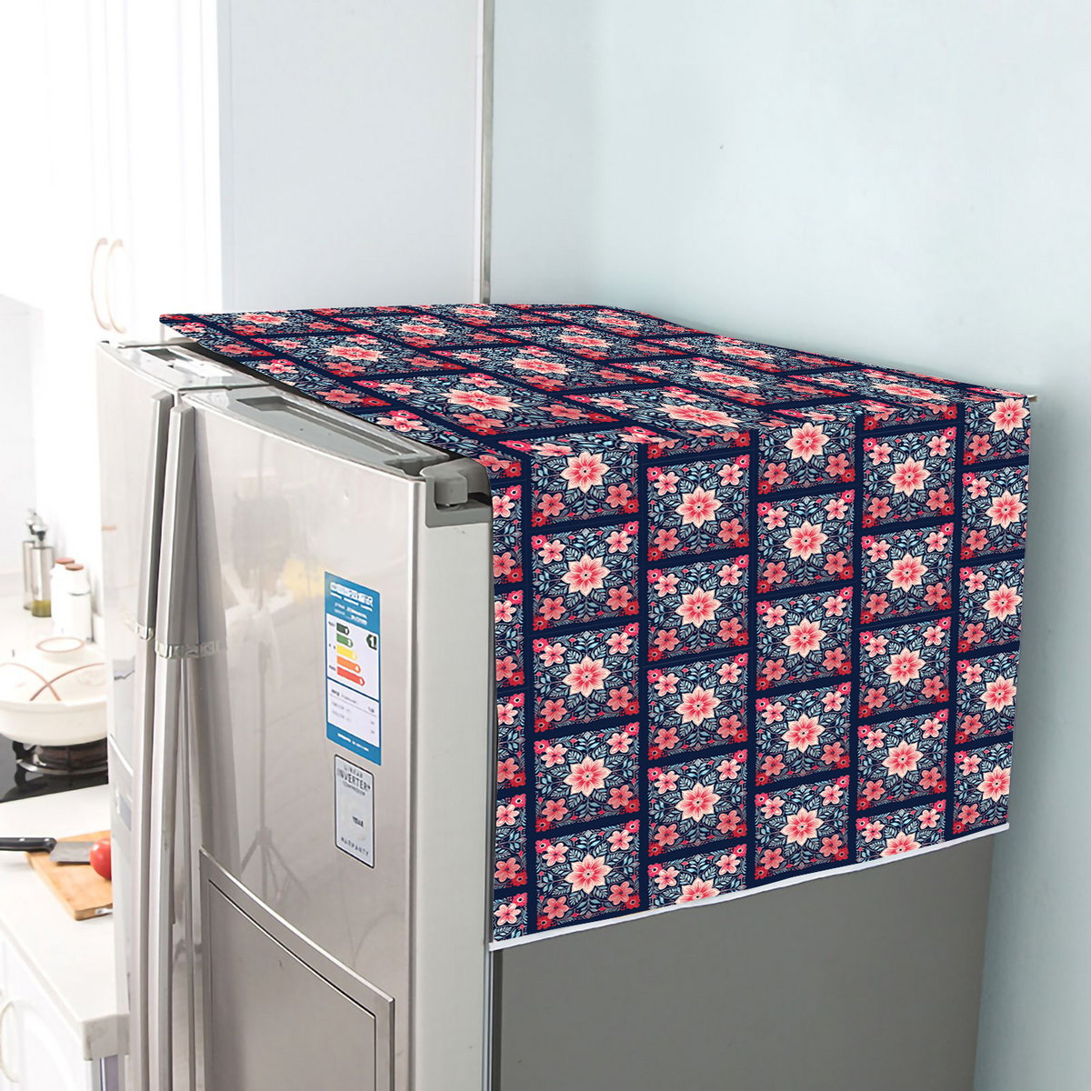 Cotton fridge cover with a pink and white floral tile print on a navy ground, draped over a refrigerator
