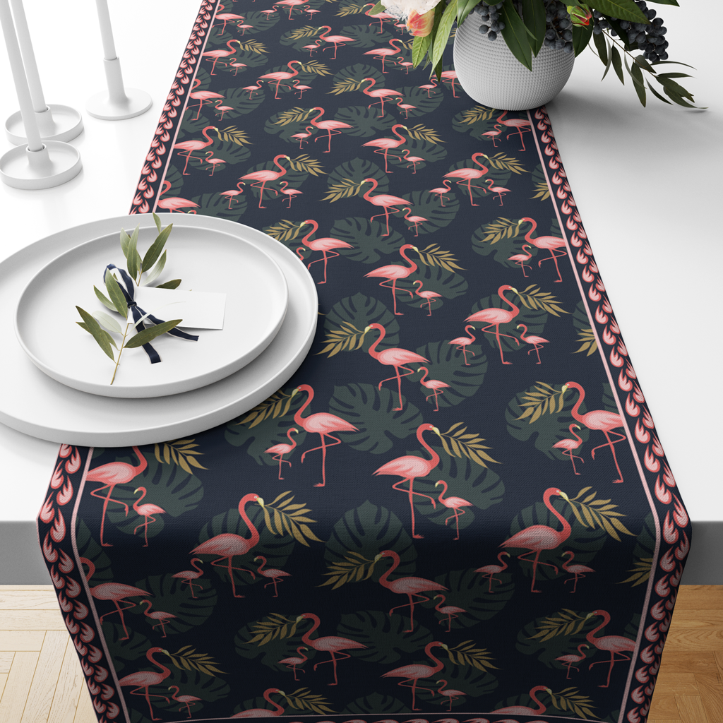 Navy cotton table runner with pink flamingo and tropical leaf print, styled with white plates