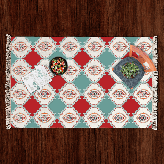 Top-down flat lay of the checkerboard floral medallion Dhurrie rug styled with a salad bowl, notecards, and a potted plant