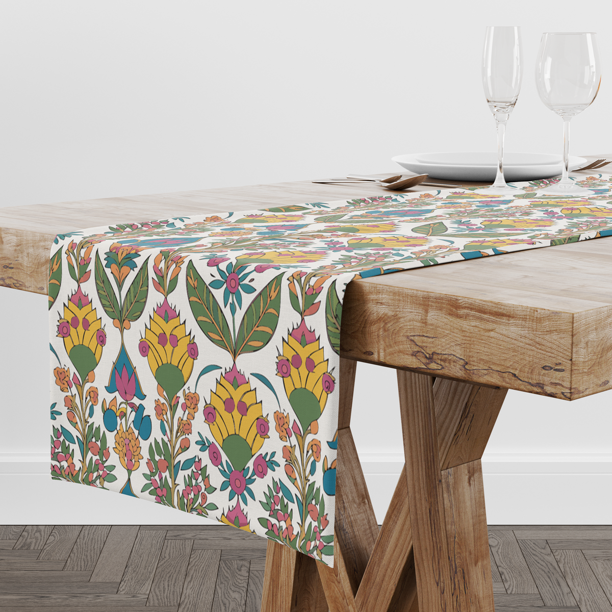 Cream table runner with a bold yellow blossom and green leaf print, pink and teal accents, styled with wine glasses and place settings