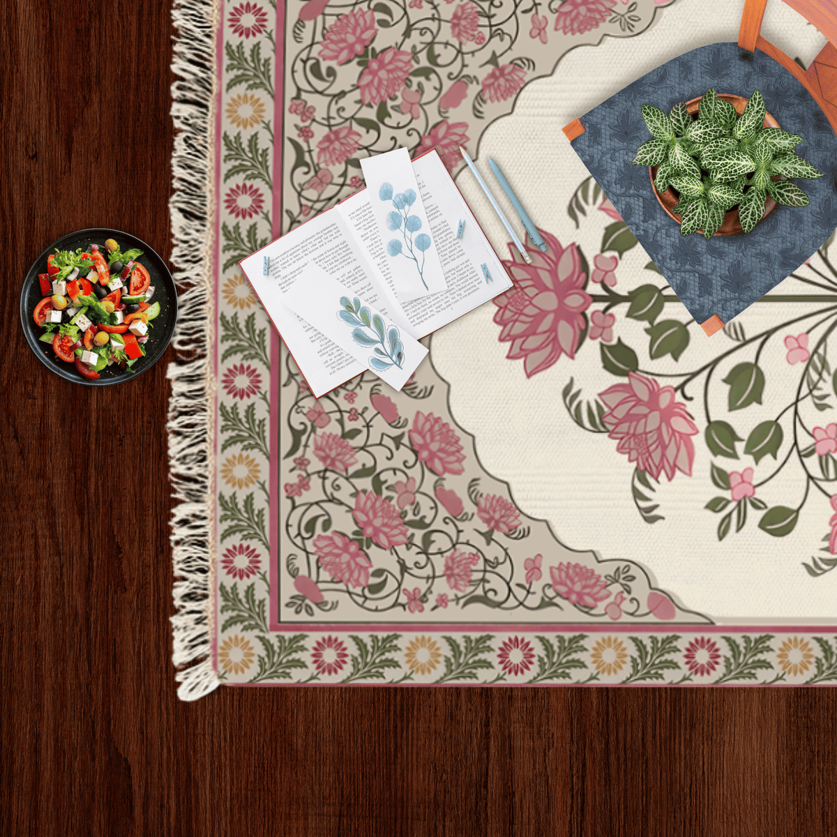 Close-up corner of the rose bouquet floral medallion Dhurrie rug styled with a small salad bowl and a potted plant