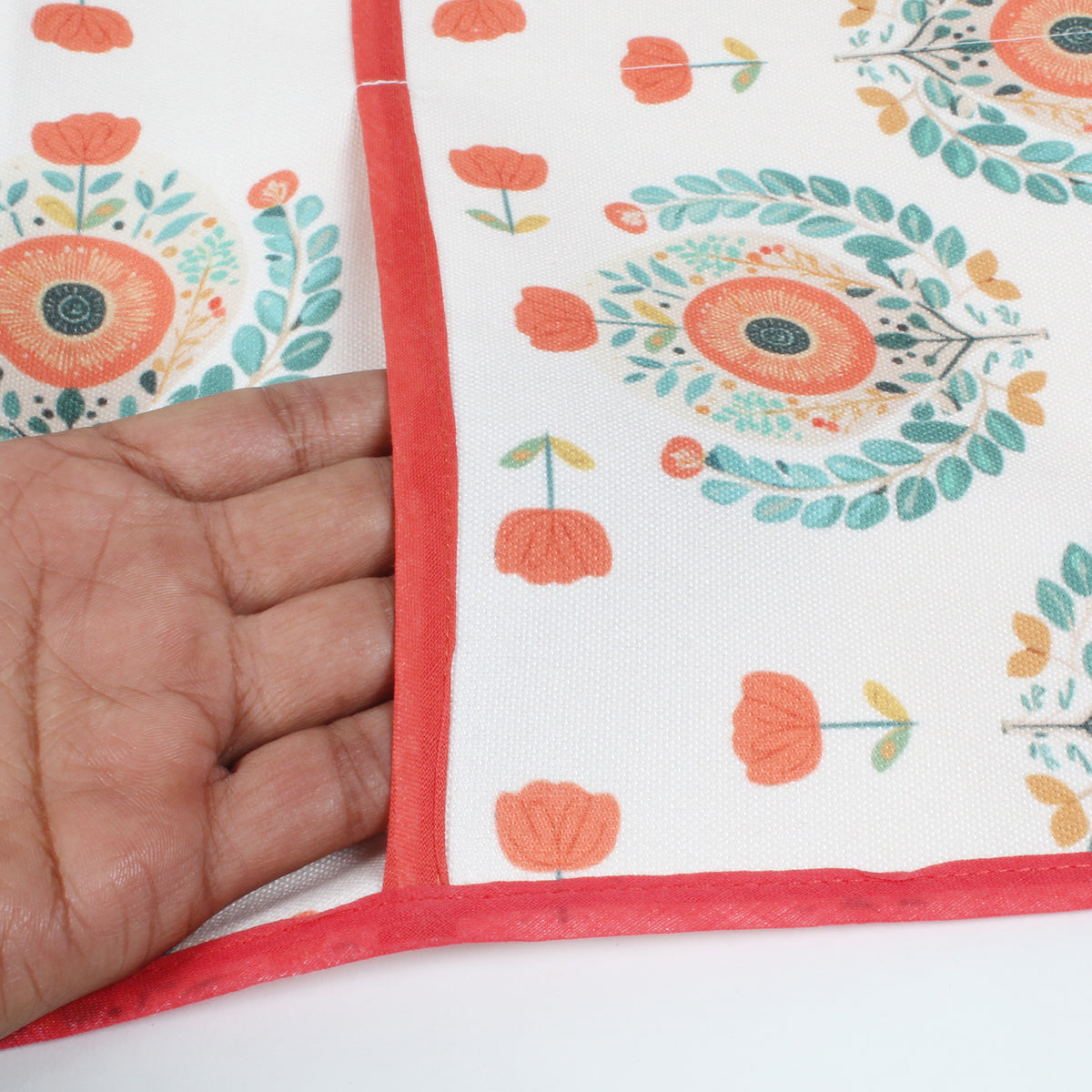 Close-up of a hand feeling the fabric of the medallion print fridge cover