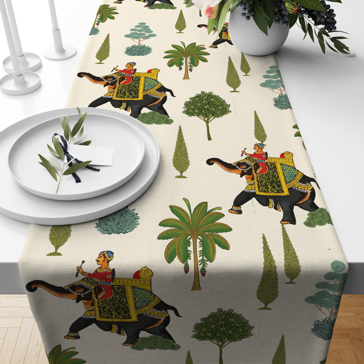 Cream table runner with decorated royal elephants, riders, and tree motifs, styled on a wooden dining table