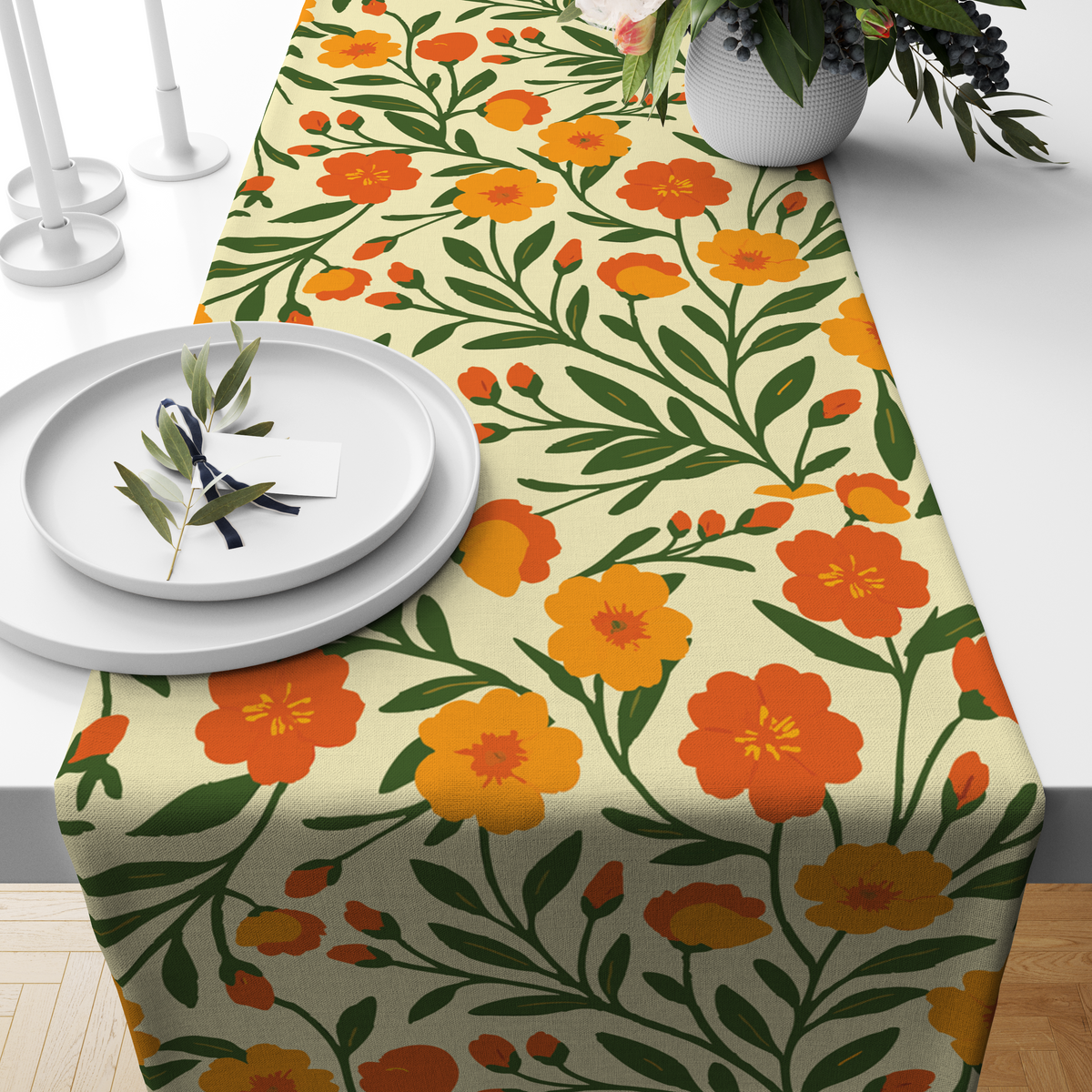 Pale yellow table runner with a bold orange and yellow floral print, styled on a wooden dining table