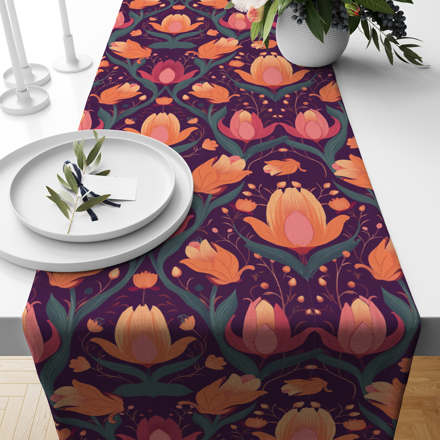 Deep plum table runner with coral-orange lotus bud motifs, styled on a wooden dining table