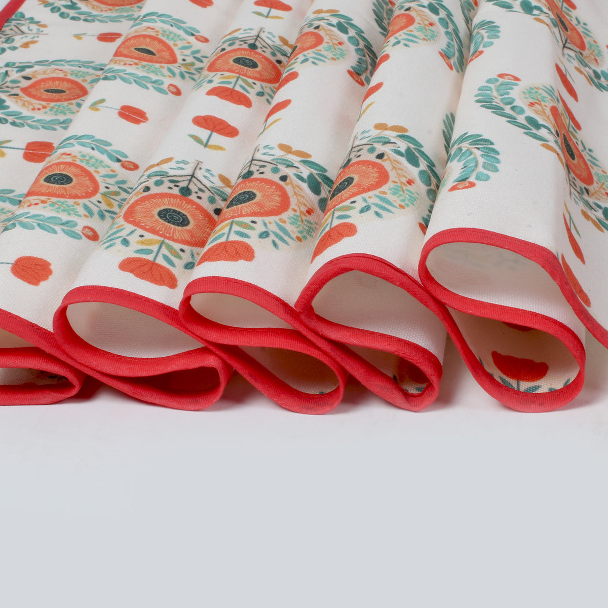 Close-up of folded fridge cover edges showing red piping trim and the medallion print fabric