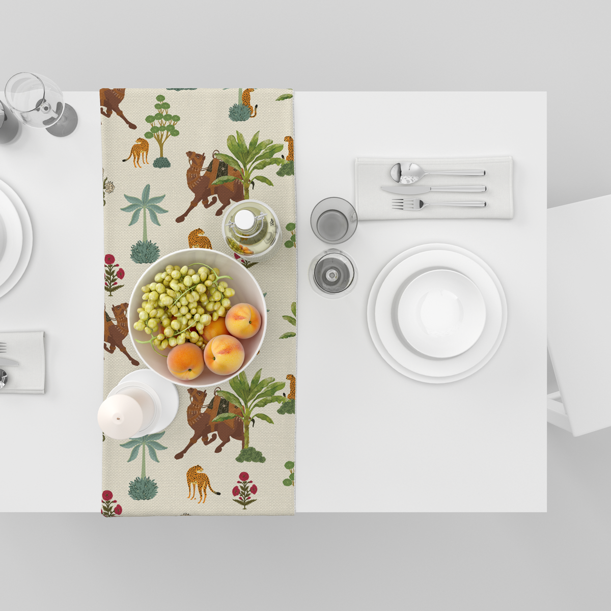 Cream table runner with camel, leopard, and palm-tree motifs, shown top-down with fruit bowl and tableware