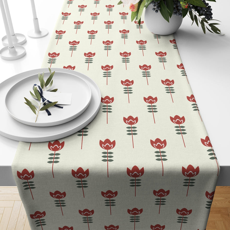 Cream table runner with a rust red tulip print, styled on a dining table with flowers