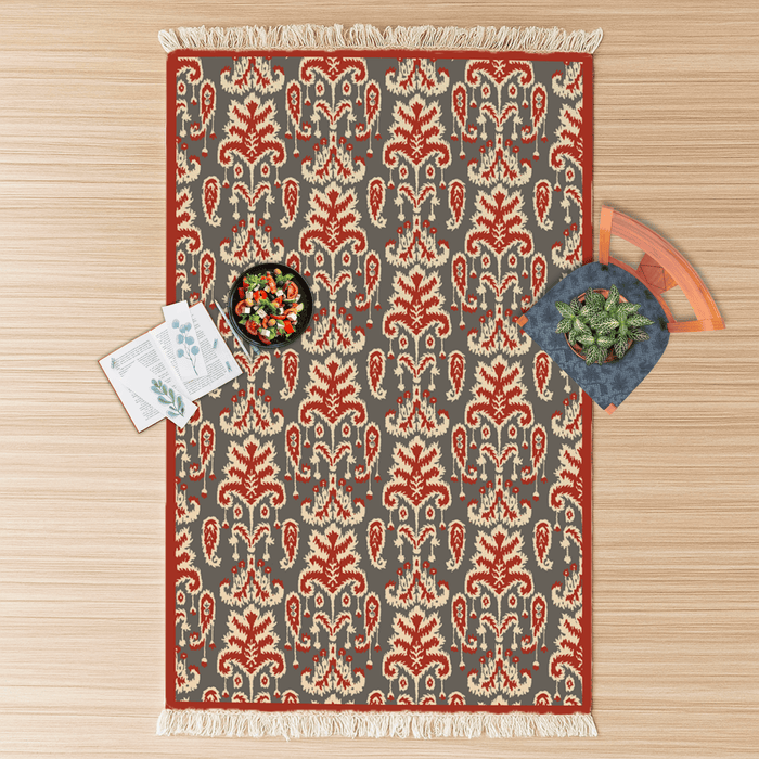 Top-down flat lay of the paisley-leaf Dhurrie rug styled with a salad bowl, notecards, and a potted plant