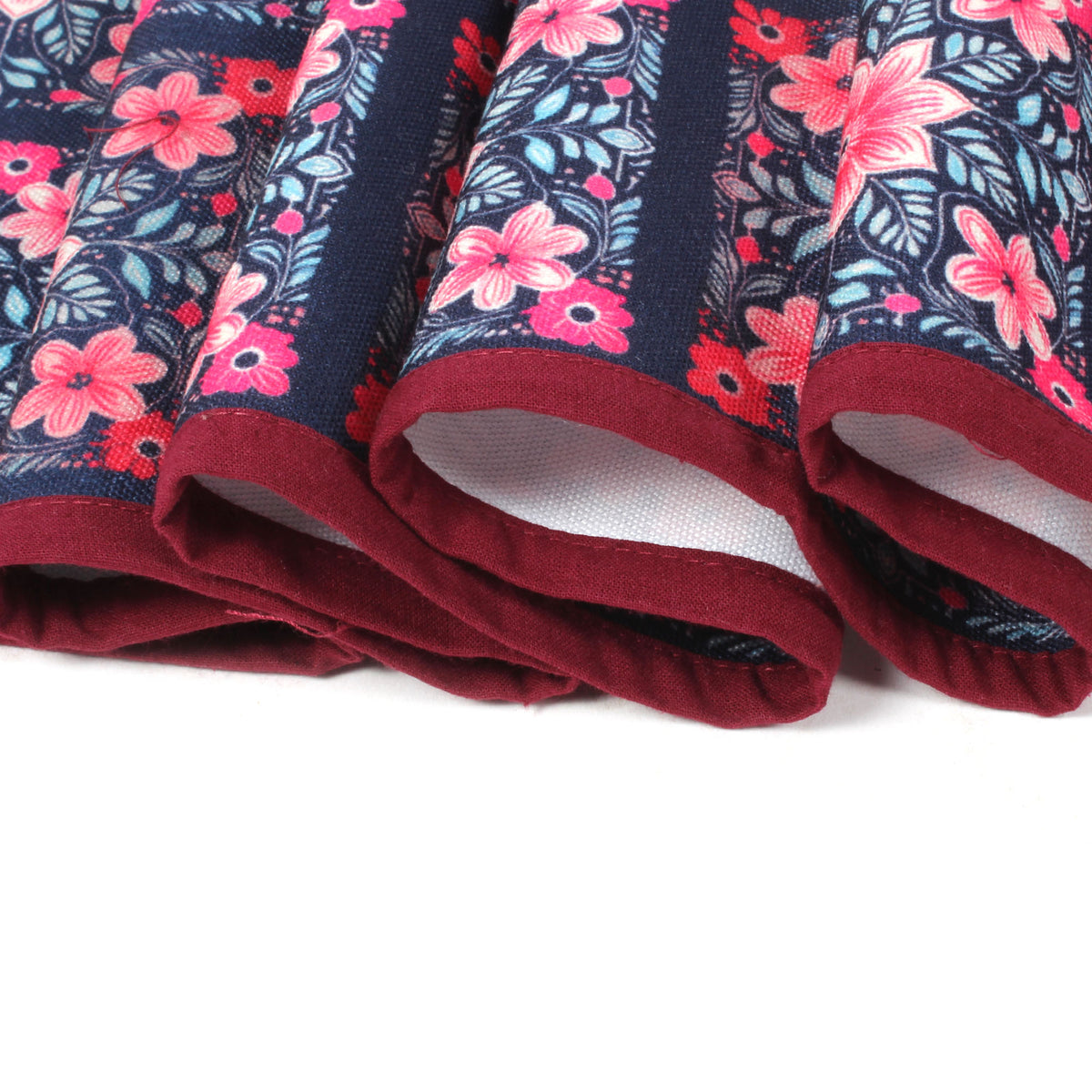 Close-up of folded fridge cover edges showing maroon trim and the floral tile print fabric