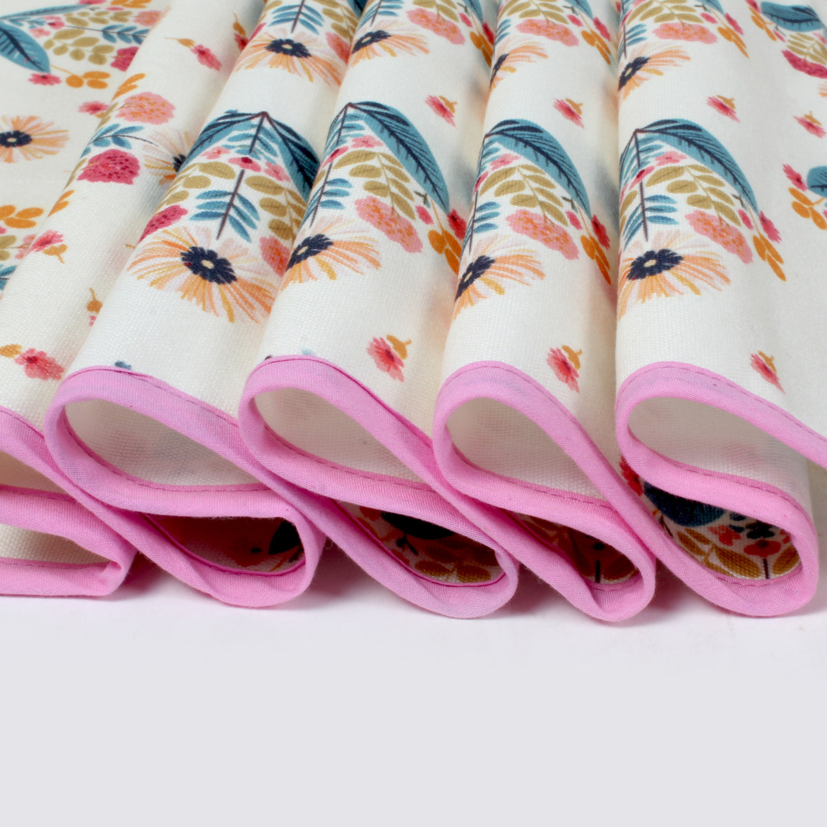 Close-up of folded fridge cover edges showing pink piping trim and floral print fabric