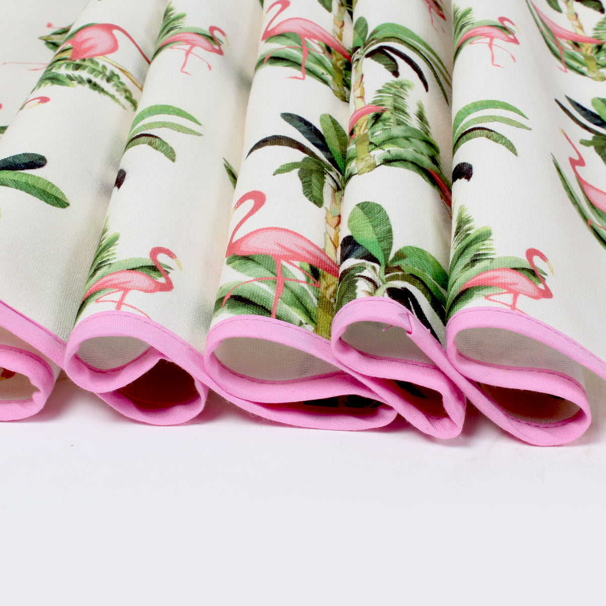 Close-up of folded fridge cover edges showing pink piping trim and flamingo print fabric