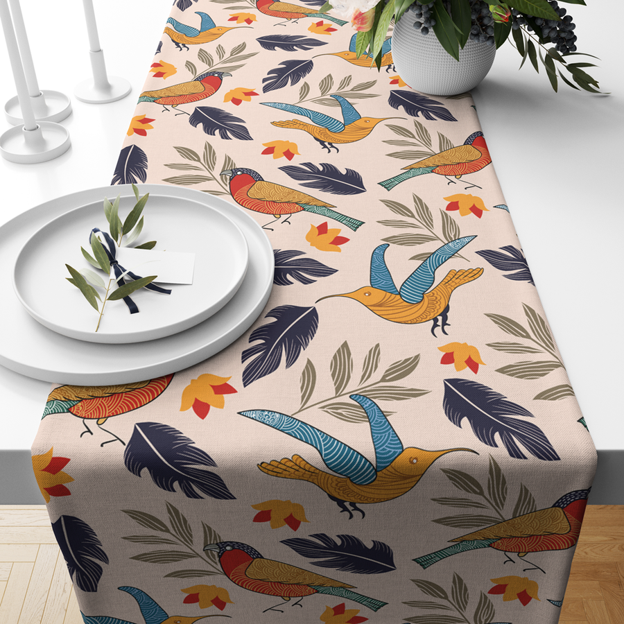 Beige cotton table runner with colorful bird and leaf print, styled with white plates