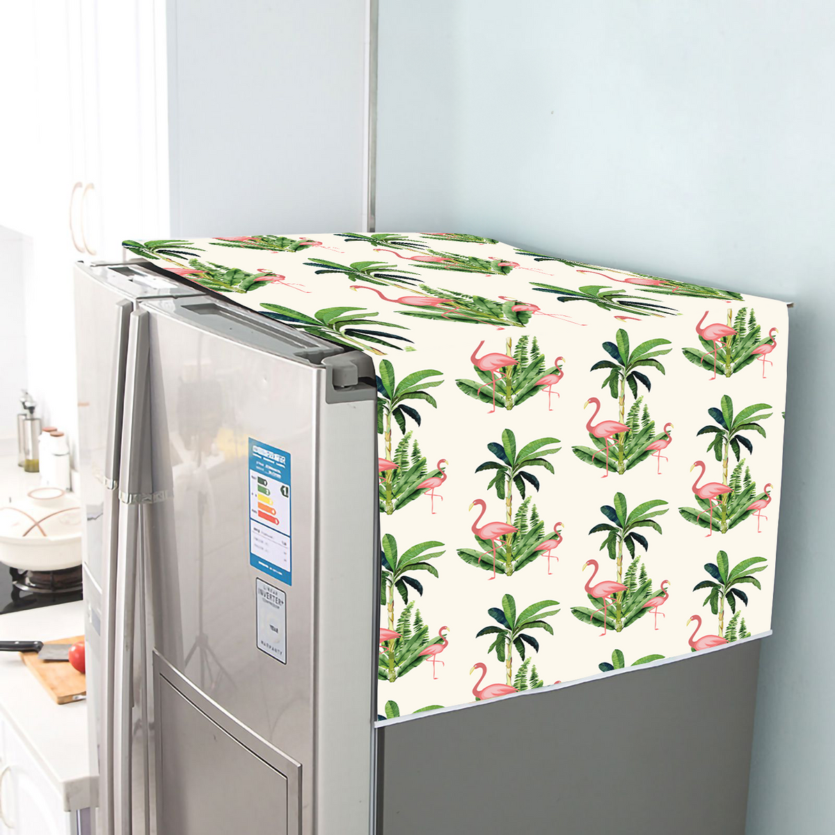 Flamingo and palm leaf print fridge cover draped over the top and side of a steel refrigerator
